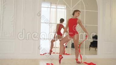 年轻漂亮的芭蕾舞演员穿着红色的衣服，红色的身体，红色的尖鞋，带着红色的丝带，一辆芭蕾舞火车，带着红色的丝带。